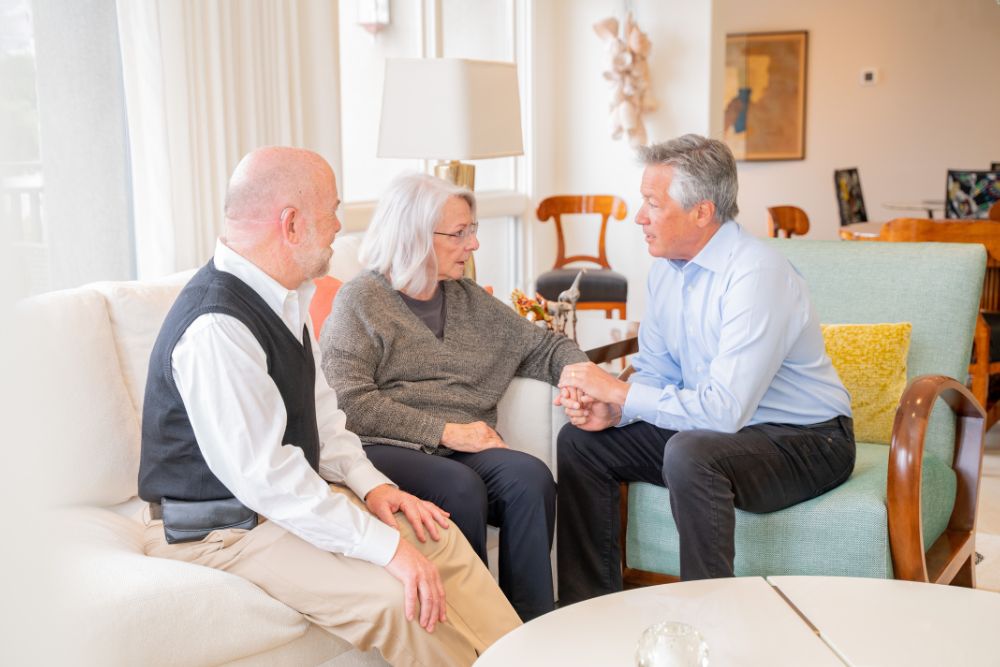 Dr. Bob Uslander in conversation with a couple in their home